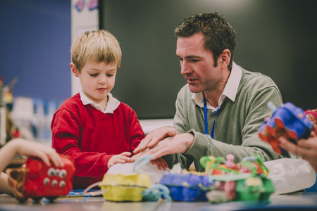 Teacher is helping his primary school student in the classroom with their STEM project.の写真素材