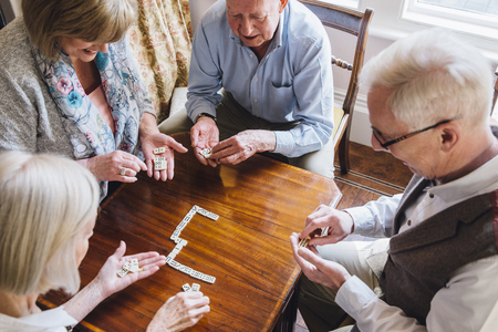 Group of senior friends are playing dominoes at a table together.の写真素材