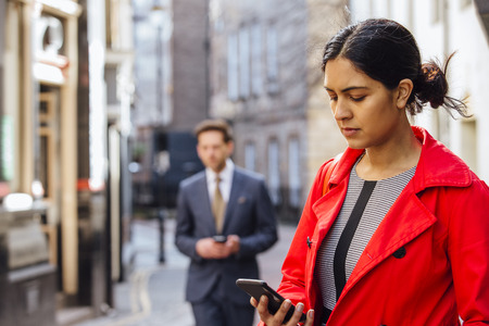 Businesspeople using smart phones in the city. の写真素材
