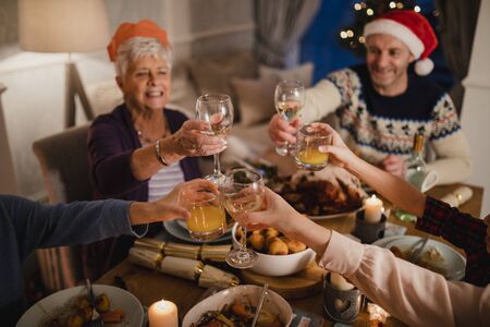 Three generation family are making a christmas toast at the dinner table.の写真素材