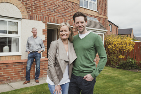 Proud father watches as his son gets a photo taken with his wife and their new first home. の写真素材