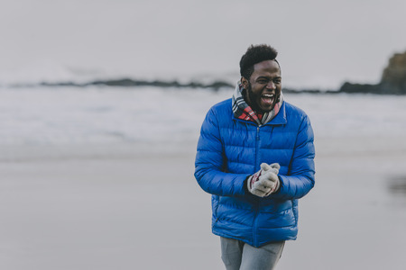 Young man laughing on a winter beach.の写真素材