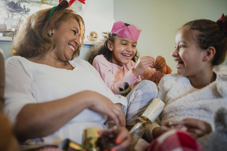 Little girls are having fun at christmas time with their grandmother. They are playing with...