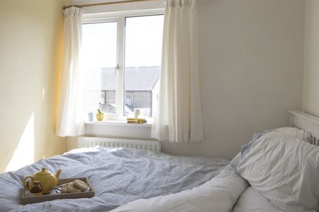 Bedroom with breakfast on the bed.