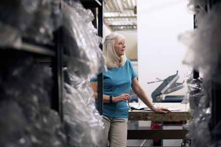 Businesswoman is reveiwing the stock in the warehouse. の写真素材