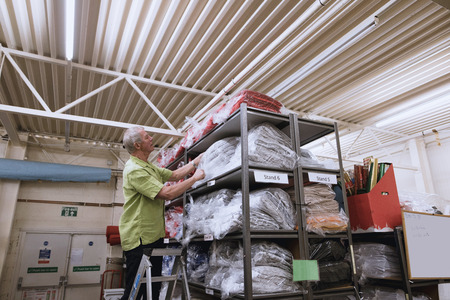 Senior businessman is getting stock from the warehouse. の写真素材