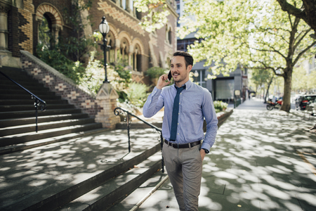 Millennial businessman is talking on his smartphone while commuting to work in Melbourne, Victoria. の写真素材