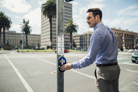 Millennial businessman is using a public crossing while commuting in Melbourne, Victoria.の写真素材