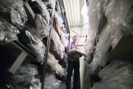 Senior businessman is getting stock from the warehouse. の写真素材