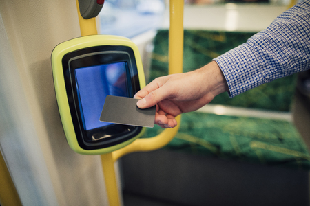 Close up shot of a commuting businessman scanning his travel card on a tram in Melbourne, Victoria.の写真素材