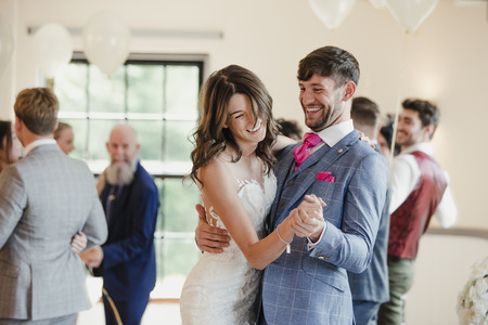 Newly wed couple are dancing together on their wedding day with all of their guests. の写真素材