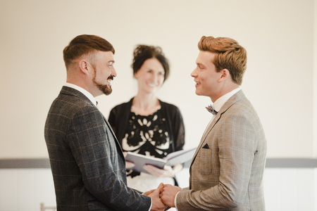 Two men are exchanging vows on their wedding day.の写真素材