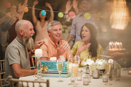 Senior man is shocked after being treated to a birthday party surprise. の写真素材