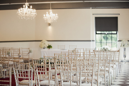 Wooden chairs lined up in a wedding venue.の写真素材