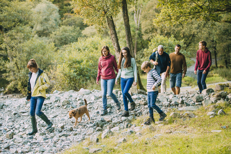 Three generation family are hiking together through the Lake District with their pet dog.の写真素材