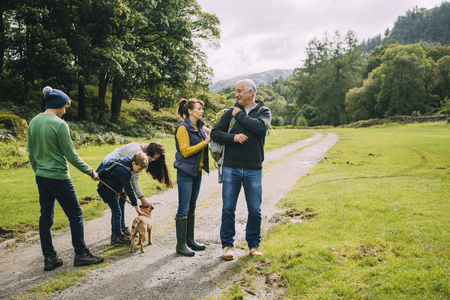 Three children are about to go for a hike with their grandparents and the dog. の写真素材