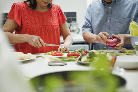 Close up shot of senior couple preparing vegetables together in the kitchen to make a stir fry.の写真素材