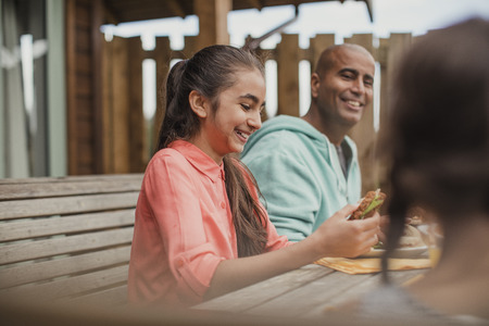 Young mixed race girl laughing at the table during brunch.の写真素材