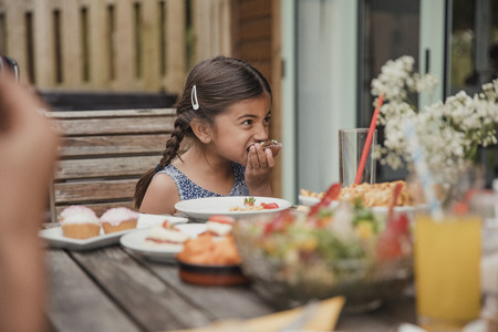 Surface level view of a little girl enjoying a chocolate cupcake.の写真素材