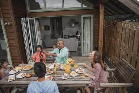 Family laughing and having fun during their brunch on vacation.の写真素材