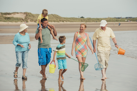 Full length shot of a family walking along the beach.の写真素材