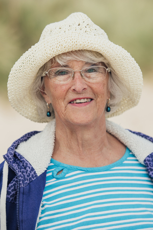 Portrait of elderly woman in casual clothing at the beach.の写真素材