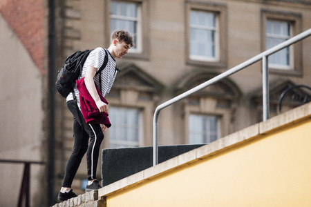 Freerunner is making his way up the side of a building to start a parkour session in the city. の写真素材