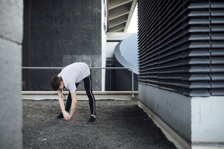 Freerunner is stretching on a rooftop. の写真素材