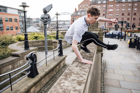 Freerunner is jumping over a wall in the city. の写真素材