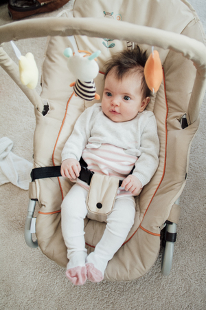 Portrait of a baby girl in her bouncer chair at home.の写真素材