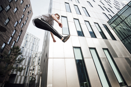Freerunner is jumping between walls in the city.