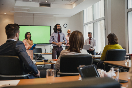 Group of business men and women giving a presentation to another small group of business men and women.の写真素材