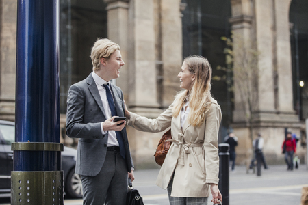 Businessman and businesswoman meeting up on the street to go to a meeting together.の写真素材