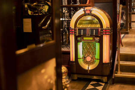 Retro jukebox in the corner of a restaurant by a set of stairs.の写真素材