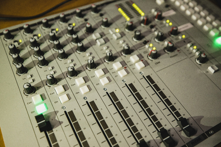 A directly above shot of a sound mixer on a desk in a radio station studio.