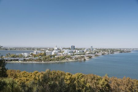 View of the city of Perth, with the Swan River and a sunny sky.