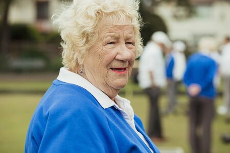 A close up shot of a senior woman smiling, looking away from the camera.