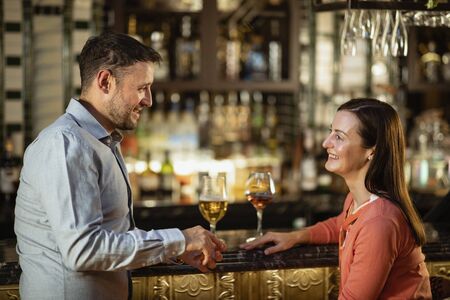 A couple having a drink together at a bar.