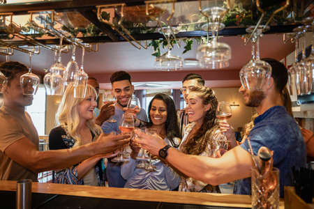 A group of friends having a celebratory toast together in a bar.の写真素材