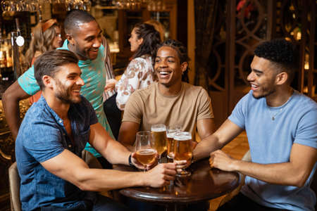 A group of male friends having a beer together at a bar.