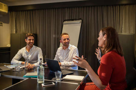 A shot of businessmen and businesswomen discussing their strategies and plans to move forward in the business, they are sitting in an office.の写真素材