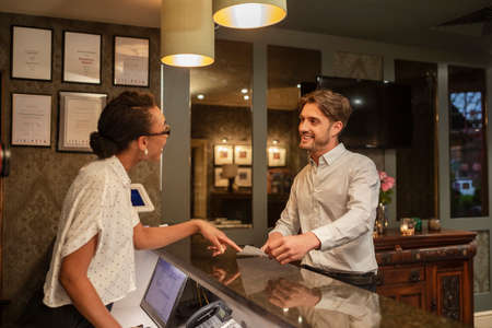 A hotel receptionist talking to a customer who is checking in to the hotel.の写真素材