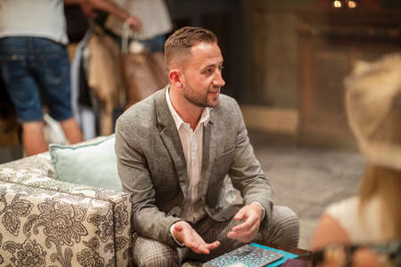 A shot of a businessman wearing smart clothing sitting in a lobby, he is talking business.の写真素材