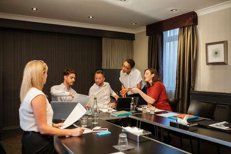 A shot of businessmen and businesswomen discussing their strategies and plans to move forward in the business, they are sitting in an office.の写真素材
