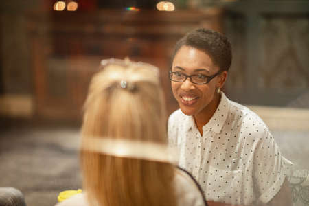A shot of two businesswomen sitting in a lobby, they are talking business.の写真素材