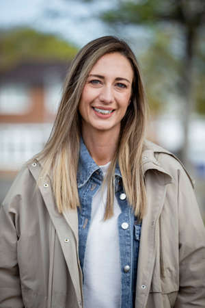 A front-view portrait shot of a mid-adult caucasian woman wearing casual clothing, she's smiling and looking at the camera.の写真素材