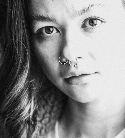 A close-up portrait of a young woman looking serious and looking at the camera.の写真素材
