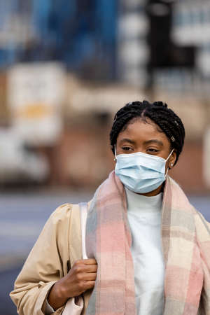 Woman wearing scarf with face covering looking awayの写真素材