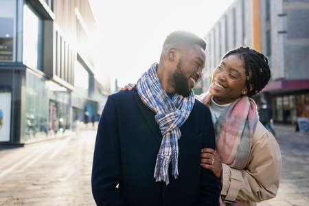 Cheerful couple wearing scraves out and about in the city centreの写真素材
