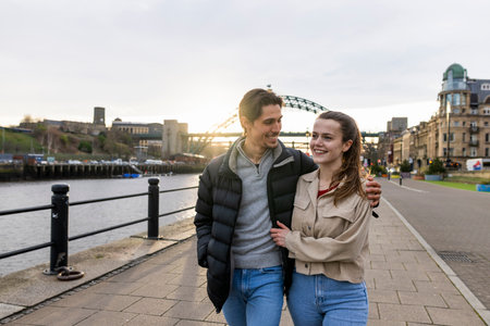 A wide-view shot of a young couple walking side by side together, they are in love.の写真素材